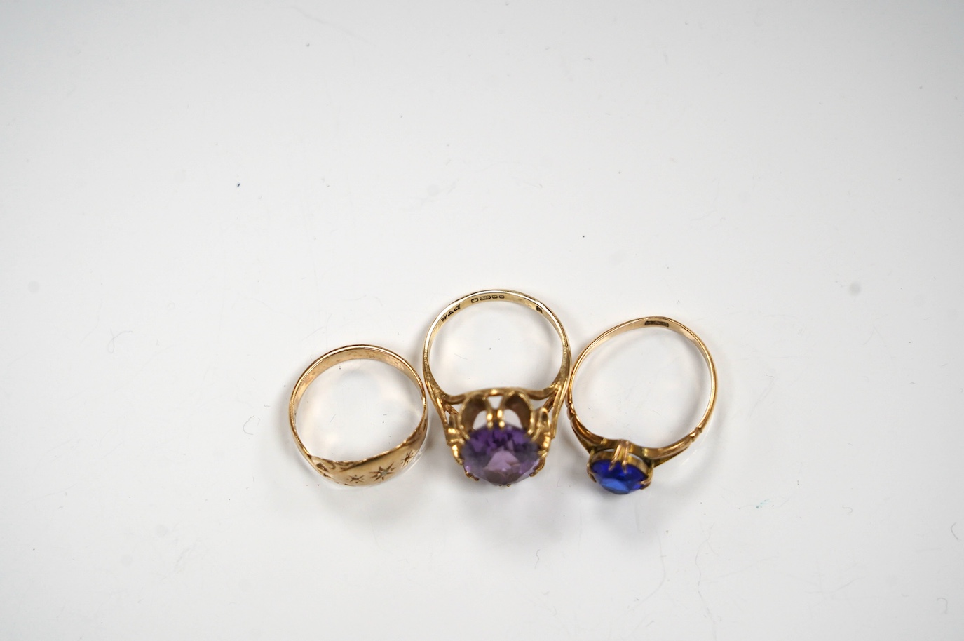 A modern 9ct gold and amethyst set dress ring, a 9ct and diamond chip set ring and a yellow metal (stamped 15c) and blue stone set ring, gross weight 8.2 grams. Condition - poor to fair